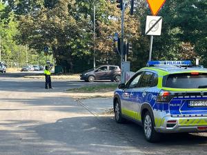 na zdjęciu radiowóz i policjant mierzący prędkość radaru