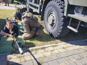 na zdjęciu żołnierz z dzieckiem z bronią