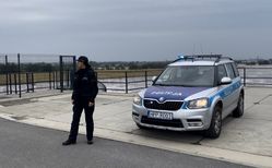 na zdjęciu policjant, radiowóz na terenie zalewowym