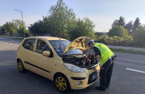 na zdjęciu policjant uruchamia samochód