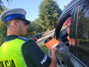 na zdjęciu policjant wręcza laurkę kierowcy