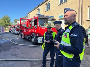 na zdjęciu policjanci i straż miejska, za nimi wóz straży pożarnej