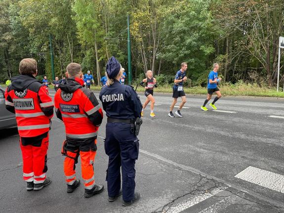 na zdjęciu biegacze, policjantka i ratownicy medyczni