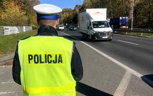 na zdjęciu policjant z ruchu drogowego i pojazd