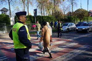 na zdjęciu policjant przy przejściu przy cmentarzu