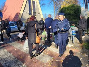 na zdjęciu policjantka rozdaje odblaski