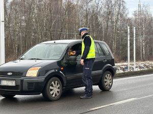 na zdjęciu policjant sprawdza stan trzeźwości kierującego