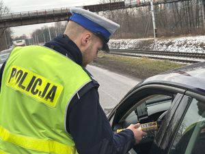 na zdjęciu policjant sprawdza stan trzeźwości kierującego