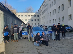 na zdjęciu policjant i młodzież przy radiowozie