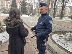 na zdjęciu policjant wręcza pieszemu odblask