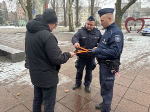 na zdjęciu policjanci wręczają odblaski