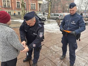 na zdjęciu policjanci wręczają odblaski