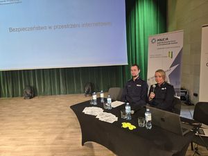 na zdjęciu prelegenci na scenie przy stoliku