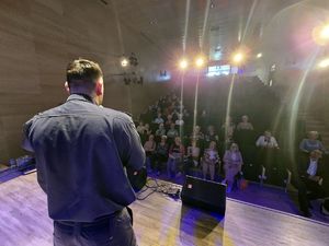 na zdjęciu policjant przemawia na scenie