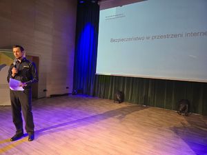 na zdjęciu policjant przemawia na scenie