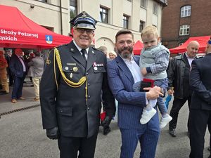 na zdjęciu strażak i mężczyzna z dzieckiem