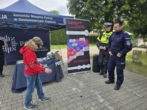 na zdjęciu policjanci i dziecko w googlach