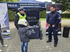 na zdjęciu policjanci i dziecko w osprzęcie policyjnym