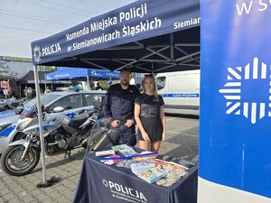 na zdjęciu policjant i członkini stowarzyszenia przy stoisku profilaktycznym