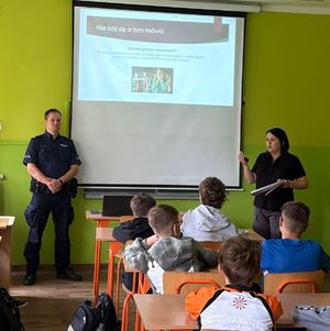 na zdjęciu policjant i pracownica MOPS prowadzą pogadankę