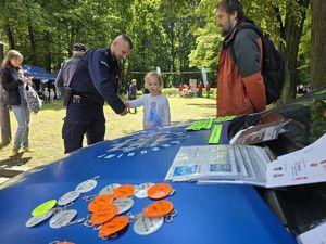 na zdjęciu policjant wręcza odblaski