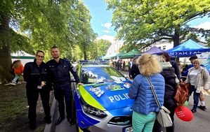 na zdjęciu strażniczka miejska i policjant przy radiowozie