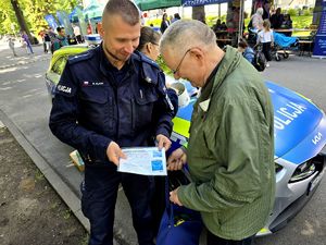na zdjęciu policjant wręcza kopertę zycia