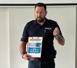 na zdjęciu policjant z ulotką