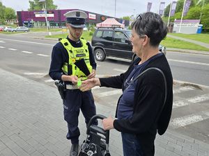 na zdjęciu policjant wręcza opaskę odblaskową