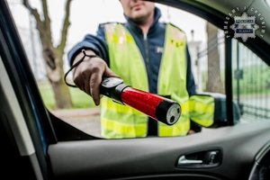 na zdjęciu policjant z urządzeniem do badania stanu trzeźwości