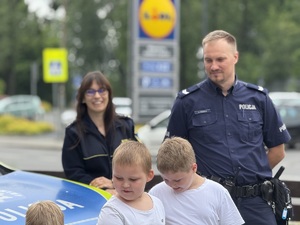 na zdjęciu policjant i dzieci przy radiowozie