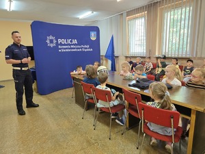 na zdjęciu policjant rozmawia z dziećmi