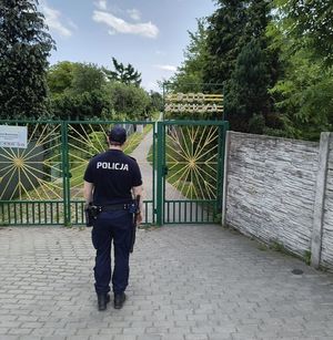 na zdjęciu dzielnicowy przed bramą ogródków