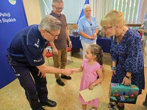 na zdjęciu komendant gratuluje dziewczynce