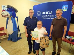 na zdjęciu komendant, członek komisji i chłopczyk z dyplomem
