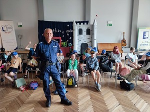 na zdjęciu policjant stoi z dziećmi