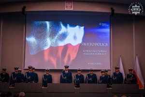 na zdjęciu slajd powitalny na auli, orkiestra i sztandar