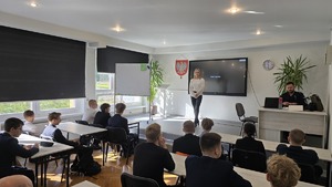 Zdjęcie przedstawia uczniów klasy wraz z psychologiem i policjantem