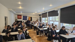 Zdjęcie przedstawia uczniów klasy wraz z policjantem prowadzącym prelekcję