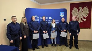 Zdjęcie przedstawia trzech dzielnicowych wraz z szefostwem siemianowickiej Policji. Obok nich stoi Drugi Zastępca Prezydenta Miasta wraz z bohaterką Sarą.