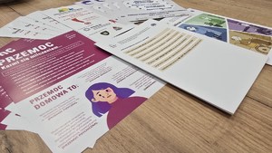 Na zdjęciu widać ułożone na stole ulotki w sprawie przeciwdziałania przemocy