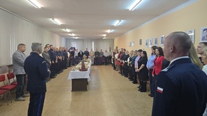 Zdjęcie przedstawia na pierwszym tle odwróconych komendantów, a w tle policjantów i pracowników cywilnych