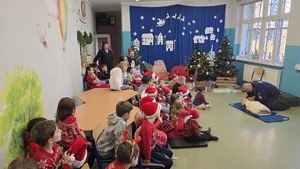 Na zdjęciu widoczny jest policjant w trakcie przekazywania dzieciom wiedzy odnośnie udzielania pierwszej pomocy.