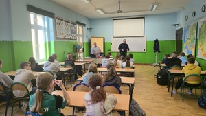 Zdjęcie przedstawia klasę w szkole podstawowej, którą szkoli policyjny profilaktyk