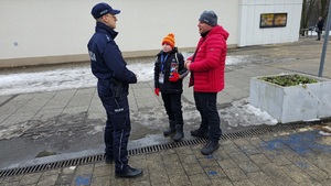 Na zdjęciu widać policjanta oraz wolontariuszy Wielkiej Orkiestry Świątecznej Pomocy