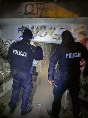 fotografia policjantów sprawdzających przejście przy rurach ciepłowniczych