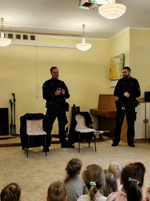 Na zdjęciu widać dzielnicowych, którzy prowadzą prelekcję wsród dzieci