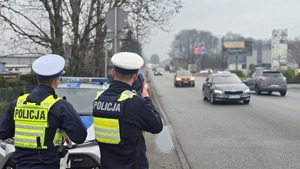 Zdjęcie przedstawia policjantów drogówki w trakcie kontroli prędkości