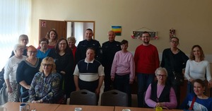 Na zdjęciu widać pozujących do zdjęcia grupowego uczestników prelekcji i dzielnicowych