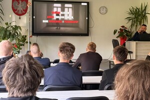 Zdjęcie przedstawia uczniów, którzy słuchają wypowiedzi profilaktycznej siemianowickiego policjanta